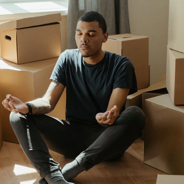 Person meditating in a bright, sunlit room, focusing on inner peace.