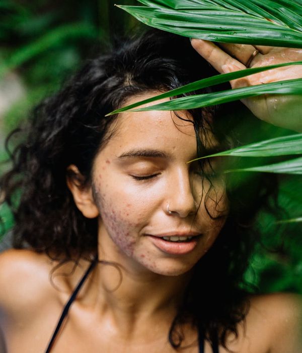 Woman with closed eyes smiling peacefully in a calm environment.